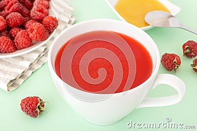 Red raspberry fruit-drink in white cup with paper straw Stock Photo