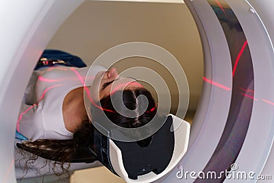 Red rays scan the girl on a CT scan of the lungs and mediastinal organs. Checking the condition of the vessels, trachea Stock Photo