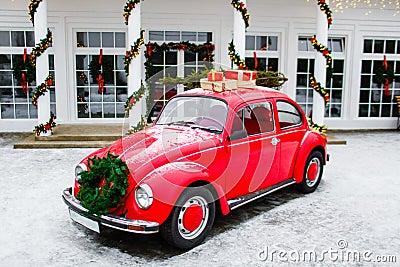 Red retro car standing in backyard. Volkswagen beetle. New year presents Editorial Stock Photo