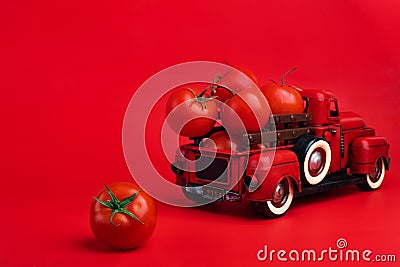 Red retro pickup truck and fresh tomatoes on red background, harvesting, ketchup advertising, creative product presentation Stock Photo