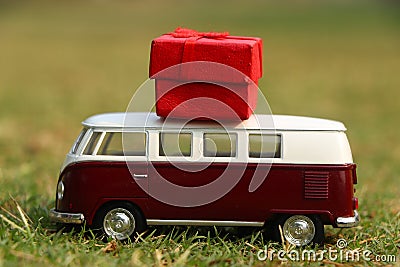 Red retro toy car with gift box. Flowers, gifts delivery concept. Stock Photo