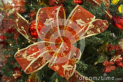 Red ribbon bow on green fir tree branch. Christmas tree ornament close photo with text place Stock Photo