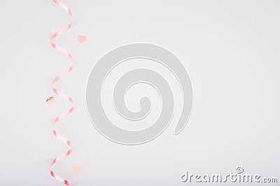 Red ribbon and glitter heart confetti on light grey background Stock Photo