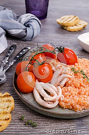 Red rice with seafood tentacles and tomatoes Stock Photo