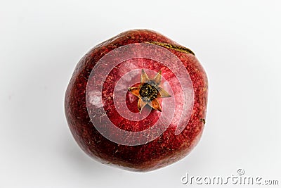 Red ripe pomegranate fruit against a white background. Anthers on ripe fruit up close. Rind outer skin of pomegranate. Macro of Stock Photo
