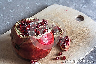Red ripe pomegranate on wooden cutting board. Fresh open ruby garnet on table. vitamin and diet concept. Juicy tropical fruit Stock Photo