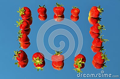 Red ripe strawberry berries laid on a mirror in the shape of a contour of a square with a reflection of the blue sky Stock Photo
