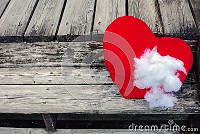 Ripped stuffed heart lying on old wooden steps Stock Photo