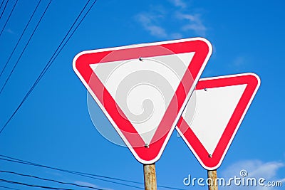 Red road sign isolated. Defocus two blank empty triangle red warning road signs with blue sky background. Danger Stock Photo