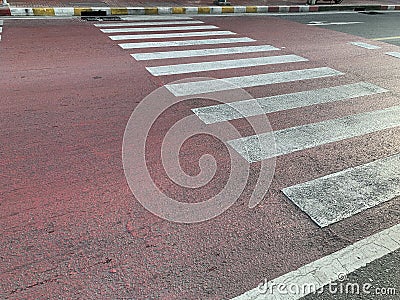 The red road with symbol for pedestrians to cross the road safely Stock Photo
