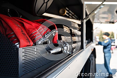 Red rolled up fire hoses in a firefighters car Stock Photo