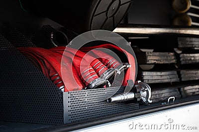 Red rolled up fire hoses in a firefighters car Stock Photo