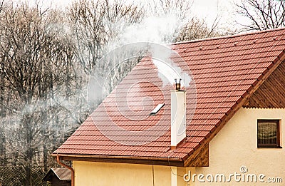 Red roof and smoking chimney Stock Photo