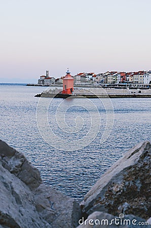 Red roofs of the historical center of old town Piran with beautiful lighthouse against the sunrise sky and Adriatic sea. Editorial Stock Photo