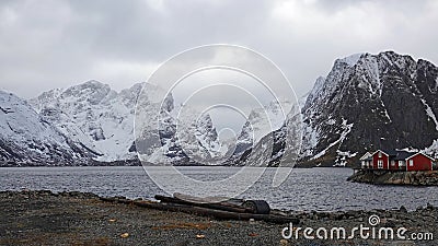 Red rorbu cottage on Reinefjorden from Toppoy island on the Lofoten in Norway in winter Stock Photo