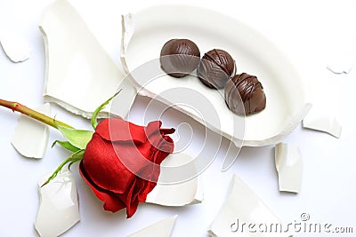 Red Rose and chocolates laying on a broken bowl Stock Photo