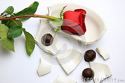 Red Rose and chocolates laying on a broken bowl Stock Photo