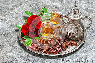 Red rose flowers with tea and dates fruits. Islamic holidays. Ra Stock Photo