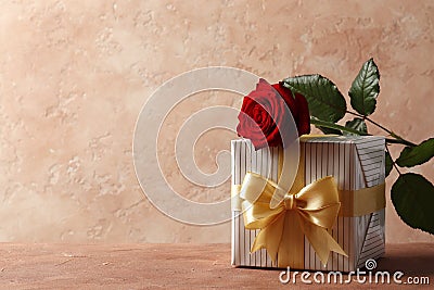 Red rose and gift box on textured Stock Photo