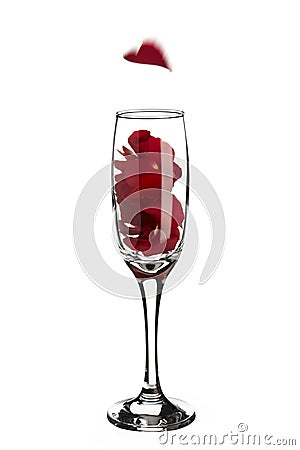 Red rose petals inside champagne glass with falling heart shaped Stock Photo