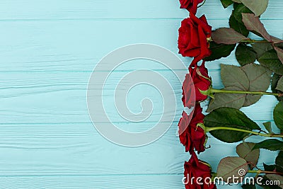 Red roses border, colorful wooden background. Stock Photo