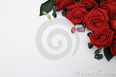 Red roses with colourful pebbles on a white background. Stock Photo