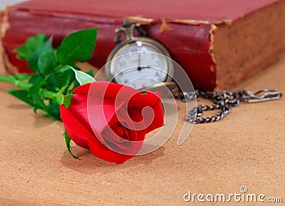 Red roses on wooden.Red rose on wooden with watch and old book . Stock Photo