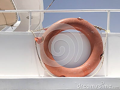 Red round lifebuoy for safety, rescue hangs aboard a boat, ship, cruise liner, yacht in a tropical marine summer resor Stock Photo