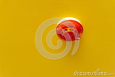 Red round smoke detectors provided on yellow ceiling background Stock Photo