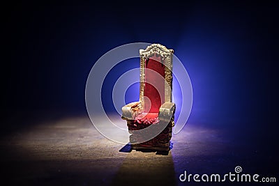 Red royal chair miniature on wooden table. Place for the king. Medieval Throne Stock Photo
