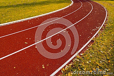 Red rubberized running track during autumn season Stock Photo