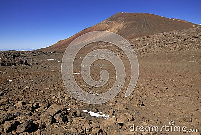 Red sands of Mauna Kea volcano with snow, Hawaii Stock Photo