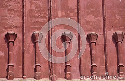 Red sanstone wall with pillars Stock Photo