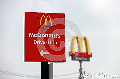 The red sign of McDonald drive thru at daylight and out focus dicut style of McDonald`s logo. Editorial Stock Photo