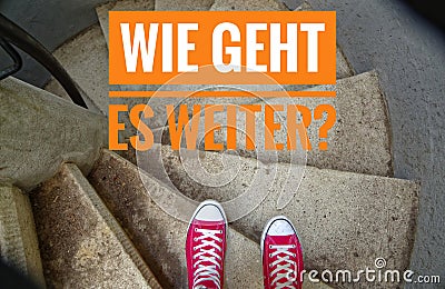 Red sneakers on spiral staircase when going downhill and the inscription in german Wie geht es weiter? in english Whats next? Stock Photo