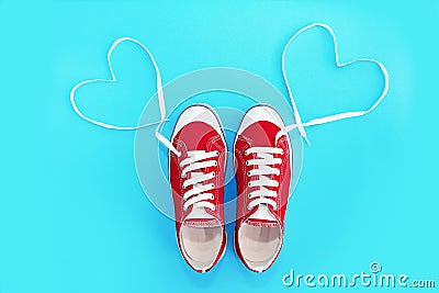 Red sneakers sport shoes with white laces and a heart pattern Stock Photo
