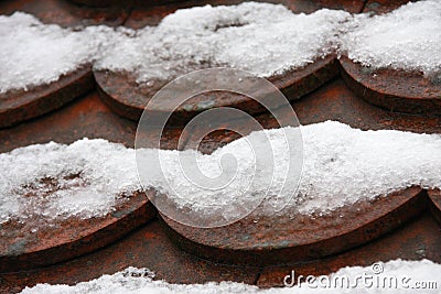 Red snow covered beaver tail roof in dew weather close up Stock Photo
