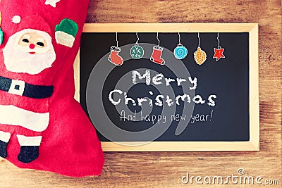 Red sock and blackboard with merry christams greeting and colorful icons. christmas card concept Stock Photo