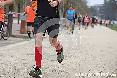 Red-Socked Athlete s Sprint in the Park During Footrace Competition Stock Photo