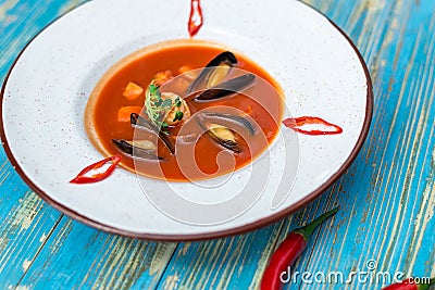 Red soup with oysters in a white plate Stock Photo