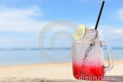 Red spirit drink lemon soda cocktail on beach Stock Photo