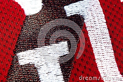 Red sportswear closeup top view. embroidered letters on the fabric. breathable knitwear. clothing details macro Stock Photo