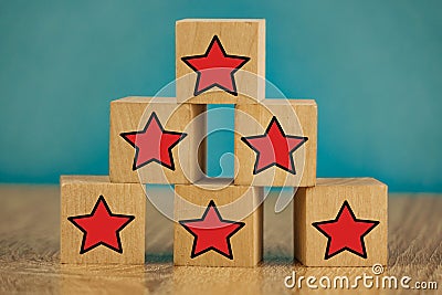 Red stars on wooden cubes on a blue background. Stars mean assessing quality. five-point rating system Stock Photo