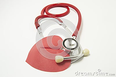 Red stethoscope chestpiece lying to red heart shape on white background vertically isolated. The idea or concept for cardiology - Stock Photo