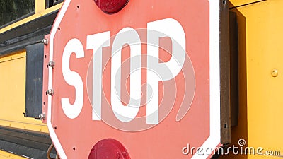 Red stop sign, yellow school bus in USA. Schoolbus or shuttle, safety on road. Stock Photo