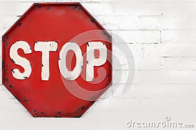 Red stop symbol on a white brick wall, object. Stock Photo