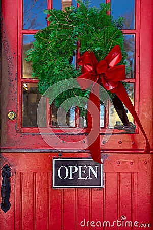 Store entrance door with open sign and Christmas wreath Stock Photo