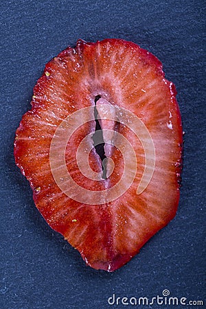 Red strawberry slice on black background, close up, top view Stock Photo