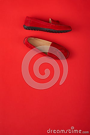 Red suede woman`s mocassin shoes over red background Stock Photo