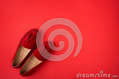 Red suede woman`s mocassin shoes over red background Stock Photo